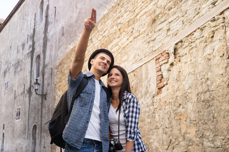 Young couple exploring an old town. Man pointing at some landmark.の写真素材