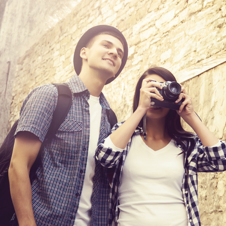 Young travelling couple: taking pictures of old town. Vacation, summer, holiday, journey: concept.の写真素材