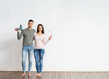 Young couple moving in a new home. Man and woman with tools and boxes.の写真素材