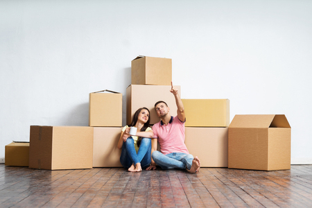 Young couple moving in a new home. Man and woman with boxes.の写真素材