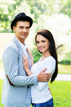 Young beautiful couple hugging in the park.の写真素材