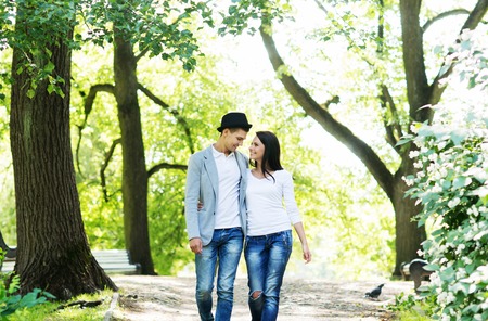Young beautiful couple being on a date and having sensual walk in the park,の写真素材