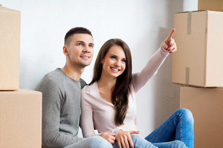 Young couple moving in a new home. Man and woman with boxes.の写真素材