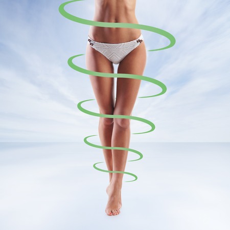 Fit and sporty legs over sea background. Body of thin and beautiful woman. Weight loss, sports, exercising, healthy food and eating, nutrition concept. Green arrows.の写真素材