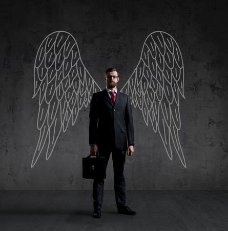 Business angel over dark background. Investment, business, sponsor concept.の写真素材