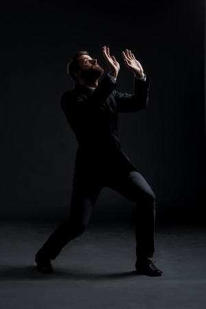 Scared businessman over black background. Business and office terror concept.の写真素材