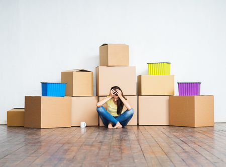 Young girl moving in a new home. Woman with boxes.の写真素材