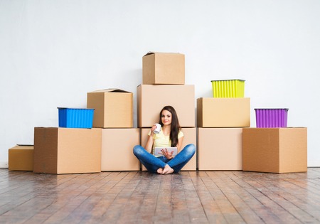 Young girl moving in a new home. Woman with boxes.の写真素材