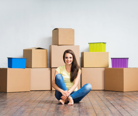Young girl moving in a new home. Woman with boxes.の写真素材