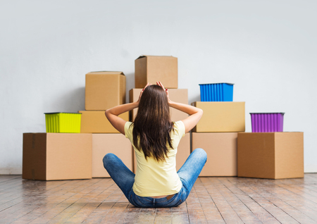 Young girl moving in a new home. Woman with boxes.の写真素材
