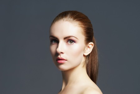 Beauty close-up portrait of beautiful, fresh and healthy girl. Human face over grey background.の写真素材