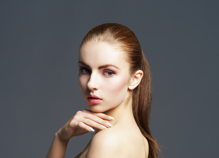 Beauty close-up portrait of beautiful, fresh and healthy girl. Human face over grey background.の写真素材