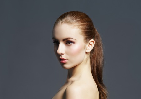 Beauty close-up portrait of beautiful, fresh and healthy girl. Human face over grey background.の写真素材