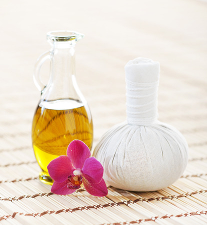 Spa aromatherapy composition with fragrant oil, orchid and ball on bamboo mat over isolated background.の写真素材