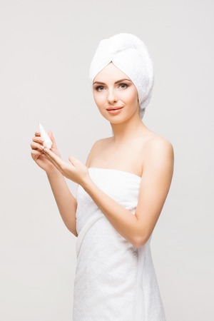 Young, beautiful and natural woman wrapped in towel isolated on whiteの写真素材