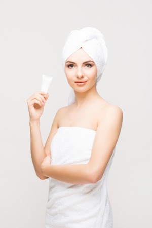 Young, beautiful and natural woman wrapped in towel isolated on whiteの写真素材