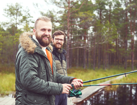 Fisherman with a spinning rod catching fish on a river. Man on a weekend. Hobby, leisure and active summer and autumn concept. Rural background.の写真素材