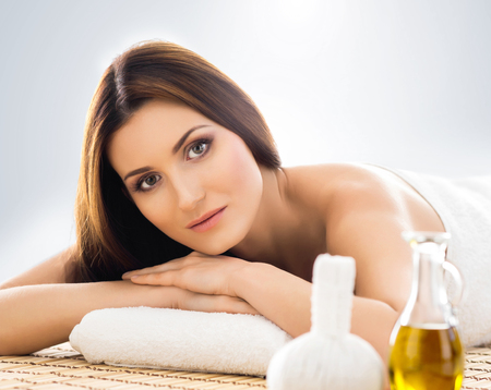 Young and beautiful girl relaxing in Christmas spa salon. Massage therapy, healing medicine and health care concept.の写真素材