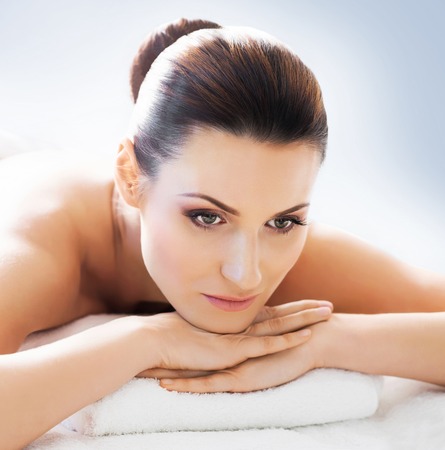 Young and beautiful girl relaxing in Christmas spa salon. Massage therapy, healing medicine and health care concept.の写真素材