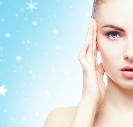 Portrait of young, beautiful and healthy woman: over winter background. Healthcare, spa, makeup and face lifting concept.の写真素材