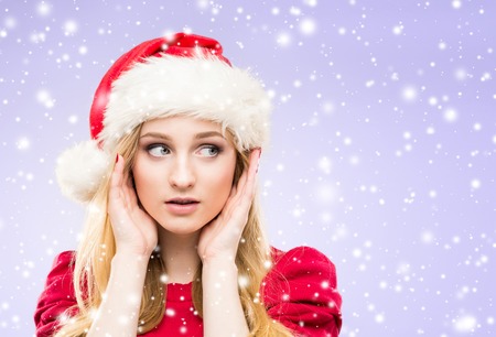 Portrait of young and beautiful girl in Christmas hat over winter backgroundの写真素材