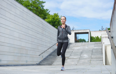 Young, fit and sporty girl running up the stairs. Fitness, sport, urban jogging and healthy lifestyle concept.の写真素材