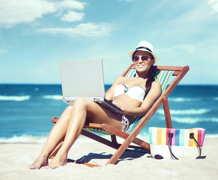 Young, beautiful, and sexy girl in white swimsuit relaxing on the beach. Traveling, resort, vacation, concept.の写真素材