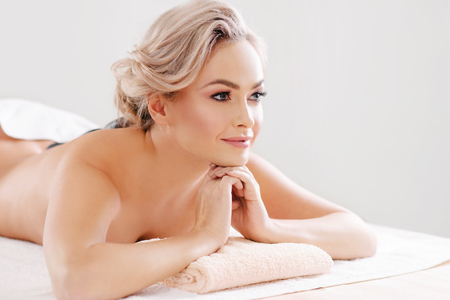 Young, beautiful and healthy woman relaxing in spa salon. Rejuvenation therapy and massaging treatments. Recreation concept.の写真素材