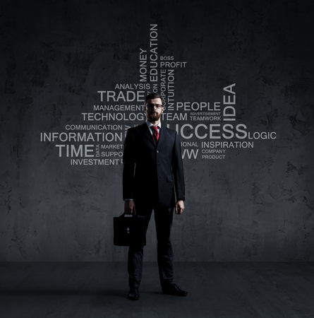 Businessman with briefcase standing over wall with text. Business, success, improvement, concept.の写真素材
