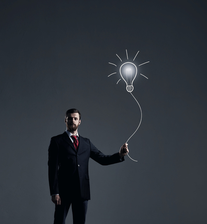 Businessman has an idea. Dark and dramatic background. Business, solution, concept.の写真素材