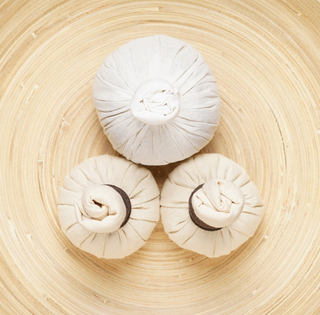 Massage bundles on a plate on bamboo mat.の写真素材