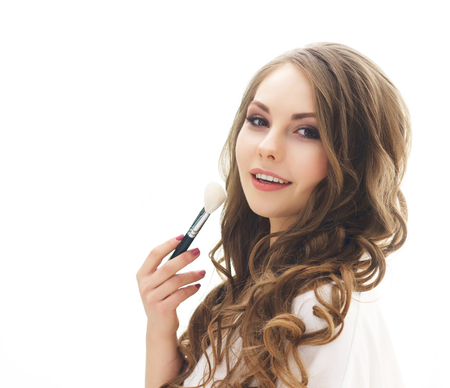 Beauty portrait of young and attractive woman with makeup brush. Make-up and cosmetics concept.の写真素材