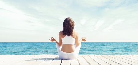 Woman meditating in lotus position outdoor. Yoga, zen, Buddhism, recovery and wellbeing concept.の写真素材