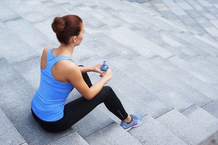 Young, fit and sporty woman resting after the training. Fitness, sport, urban jogging, healthy lifestyle concept.の写真素材