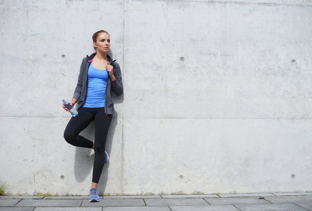 Young, fit and sporty woman resting after the training. Fitness, sport, urban jogging and healthy lifestyle concept.の写真素材