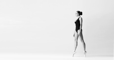Graceful ballerina dancing in art performance. Young and beautiful ballet dancer in black and white.の写真素材