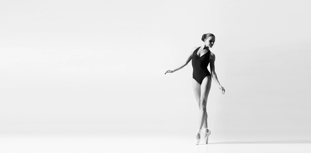 Graceful ballerina dancing in art performance. Young and beautiful ballet dancer in black and white.の写真素材