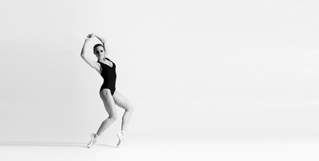 Graceful ballerina dancing in art performance. Young and beautiful ballet dancer in black and white.の写真素材
