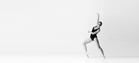 Graceful ballerina dancing in art performance. Young and beautiful ballet dancer in black and white.の写真素材