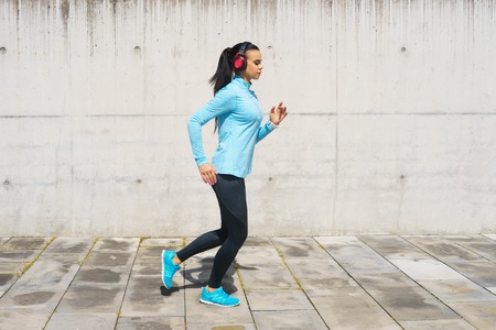 Young, fit and sporty woman running up the stairs. Fitness, sport, urban jogging and healthy lifestyle concept.の写真素材