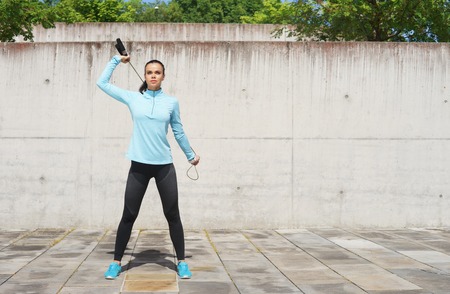 Young, fit and sporty woman jumping with a skipping rope. Fitness, sport, urban jogging and healthy lifestyle concept.の写真素材