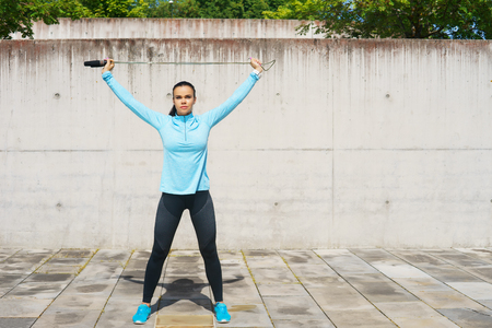 Young, fit and sporty woman jumping with a skipping rope. Fitness, sport, urban jogging and healthy lifestyle concept.の写真素材