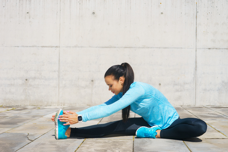 Young, fit and sporty girl stretching. Fitness, sport, urban jogging and healthy lifestyle concept.の写真素材