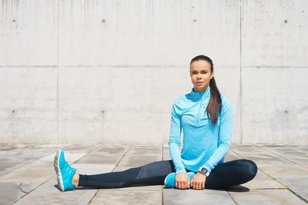 Young, fit and sporty girl stretching. Fitness, sport, urban jogging and healthy lifestyle concept.の写真素材