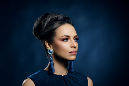 Young, beautiful and rich woman in jewels of platinum and stones over luxury backgroundの写真素材