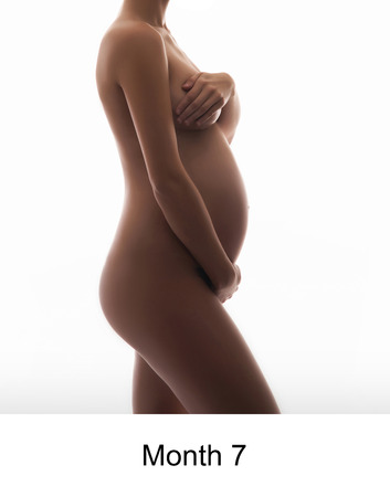 Naked pregnant woman isolated on whiteの写真素材