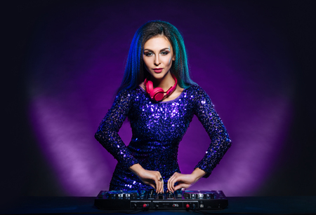 Young, beautiful and sexy dj girl playing music on a disco party in a night clubの写真素材