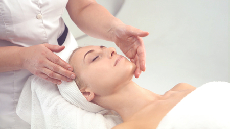Young attractive woman getting spa treatment over white background.の写真素材