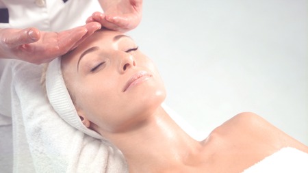 Young attractive woman getting spa treatment over white background.の写真素材