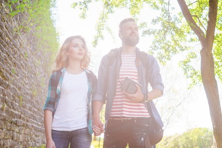 Young travelers walking in a park. Man and woman having vacation. Backpackers, traveling and tourism.の写真素材